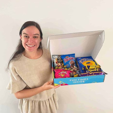 Happy girl with her tasty colourful snack box hamper